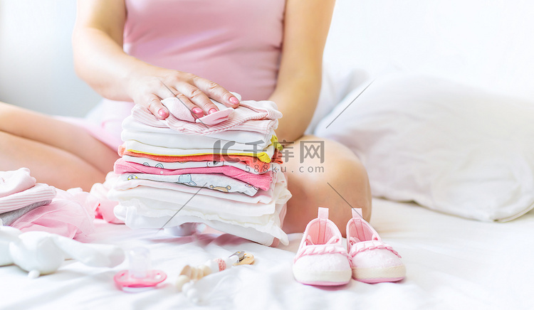 一名孕妇正在折叠婴儿用品。