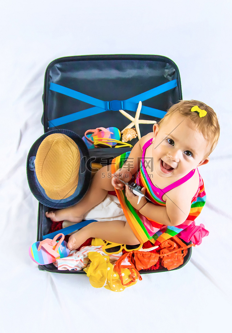 宝宝坐在行李箱里，准备去旅行。