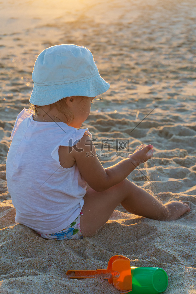 巴拿马草帽的小女孩在海滩上玩耍