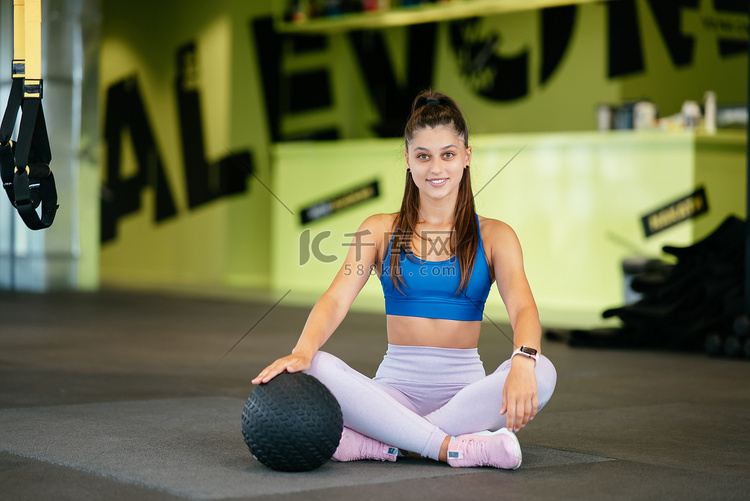 年轻的运动女性在健身房里看着镜
