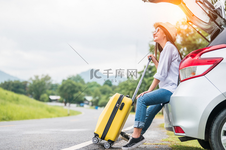 亚洲女人带着黄色行李在公路旅行