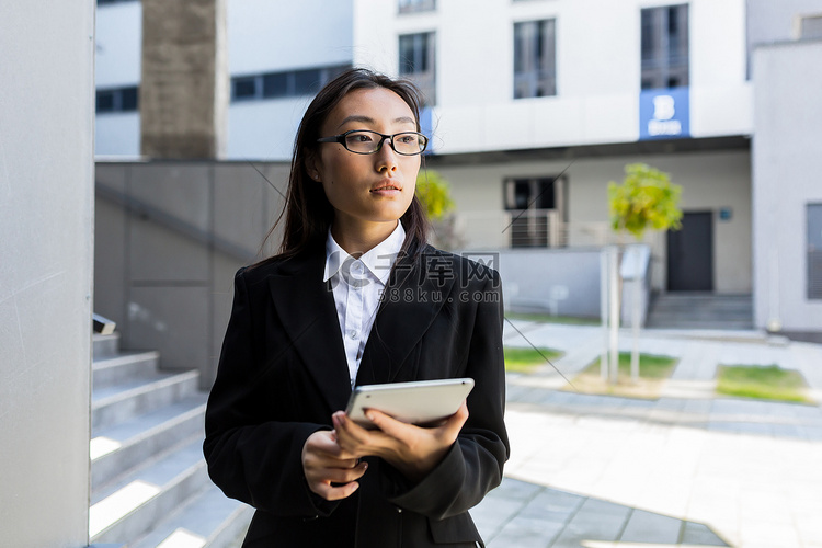 身穿商务正装的亚洲女商人站着，