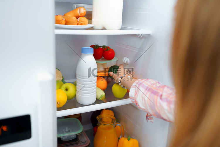 从冰箱里拿食物的女人的手