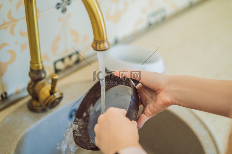 女人在水龙头里洗香薰机。