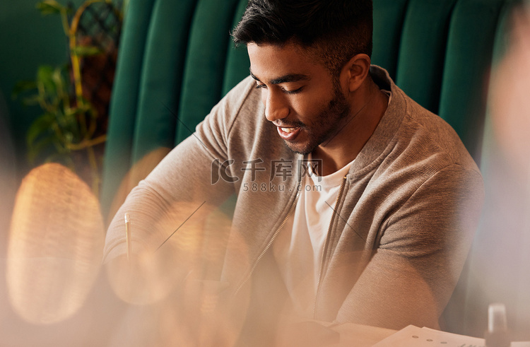 英俊的印度男子独自坐在咖啡馆里