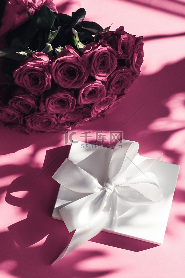 豪华假日丝绸礼盒和粉色背景玫瑰
