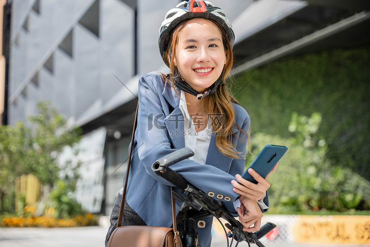 带头盔的女性在街上骑自行车上班