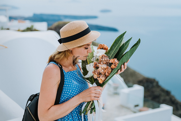 美丽的女孩带着花束走在希腊欧洲