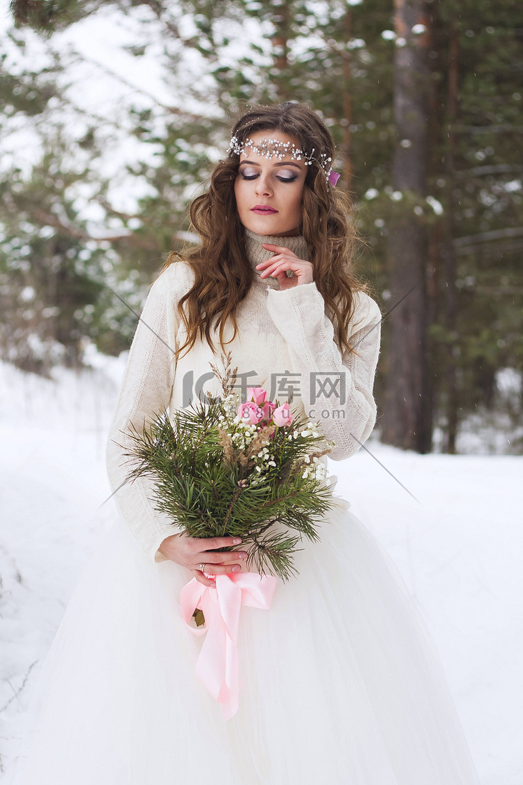 美丽的新娘穿着白色连衣裙，在冰