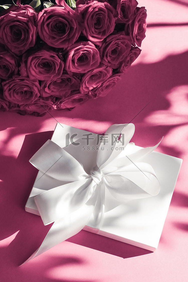 豪华假日丝绸礼盒和粉色背景玫瑰