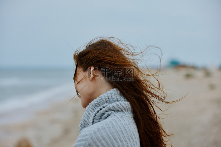 穿毛衣的女人飞扬的头发 海边旅