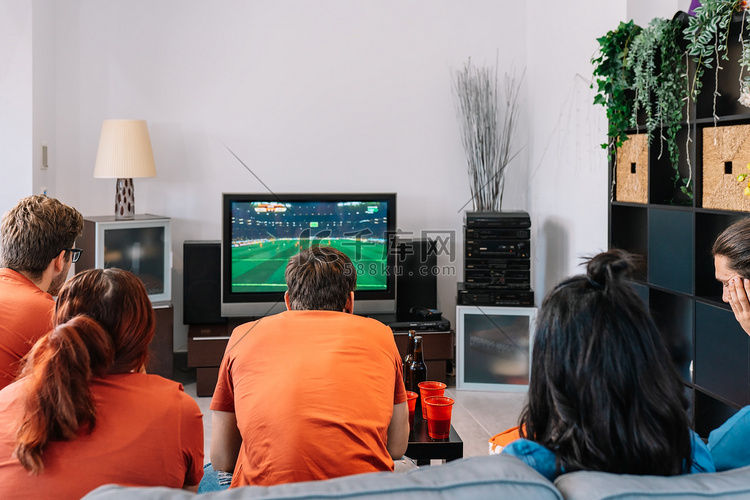 朋友们在家里专心看电视上的足球