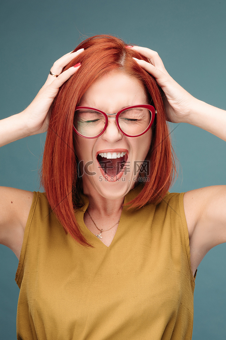 戴眼镜的快乐而积极的红发女人双