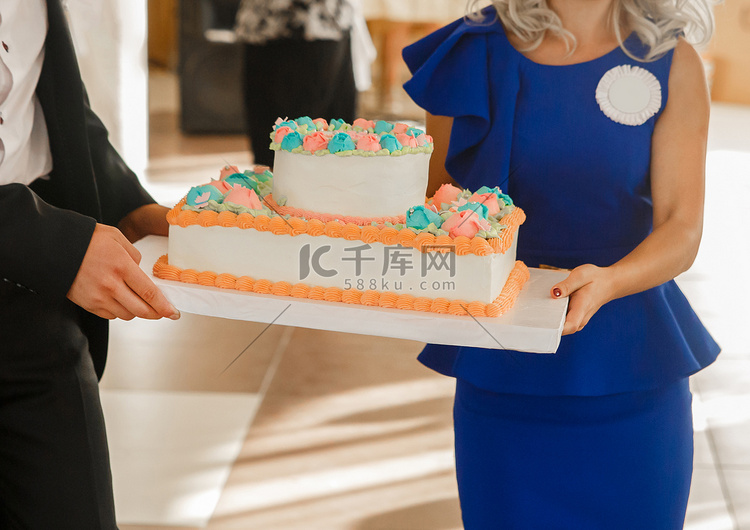 男人和女人在婚礼上手拿生日蛋糕