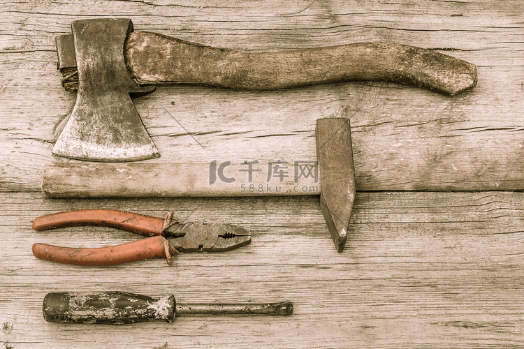 旧木质表面上的旧染色斧头、锤子