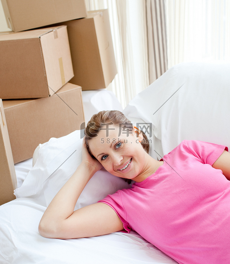 快乐的女人在带盒子的沙发上放松