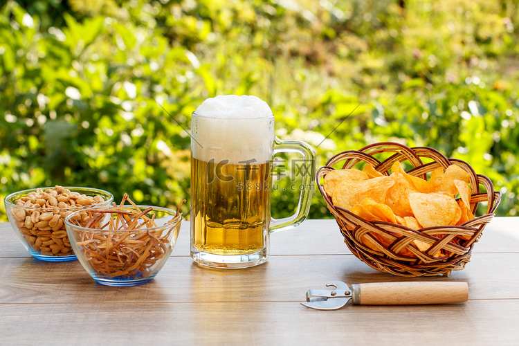 木桌上的玻璃杯啤酒，柳条篮里放