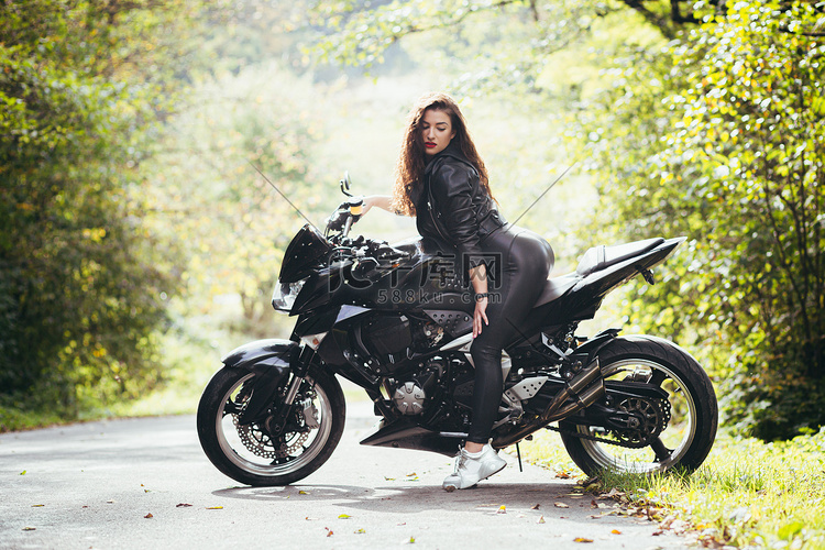 一位美丽的年轻女子坐在摩托车上