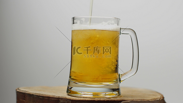 将啤酒倒入带有手柄的啤酒杯中，