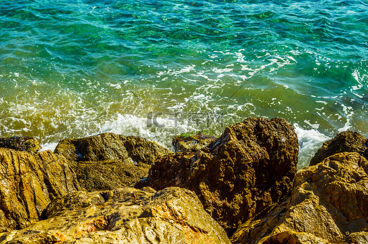 炎热的一天，海水冲击岩石海岸，