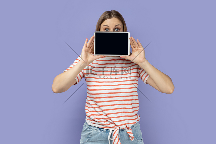 女人用平板电脑遮住半张脸，显示