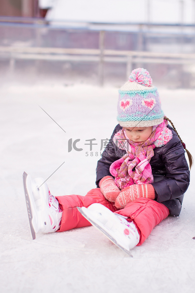 秋天后坐在溜冰场上的悲伤小女孩