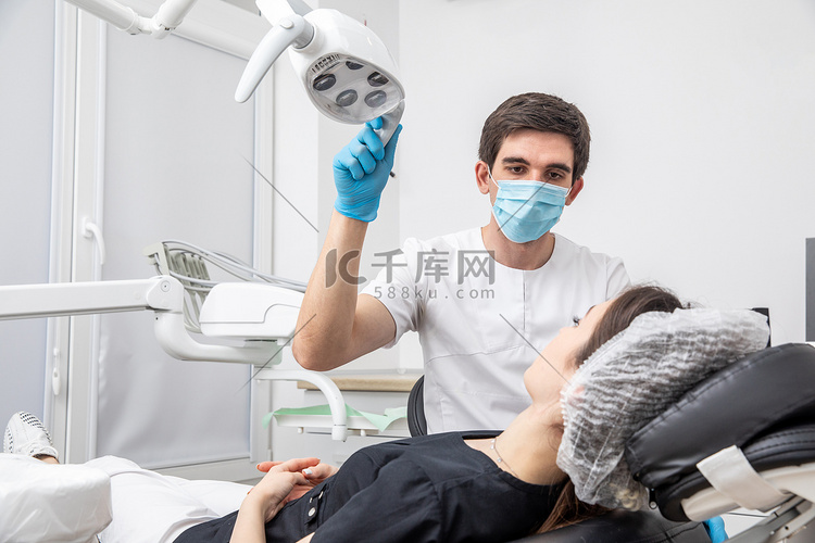 牙医在牙科诊所调整牙科灯。
