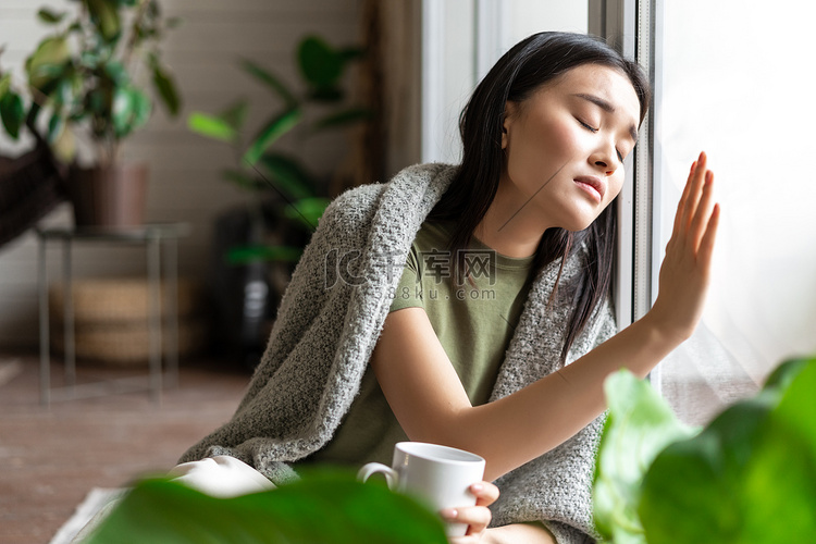 伤心欲绝的亚洲女人触摸玻璃窗，