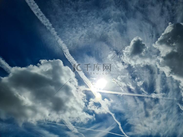 蓝天中一些云层之间的飞机凝结尾
