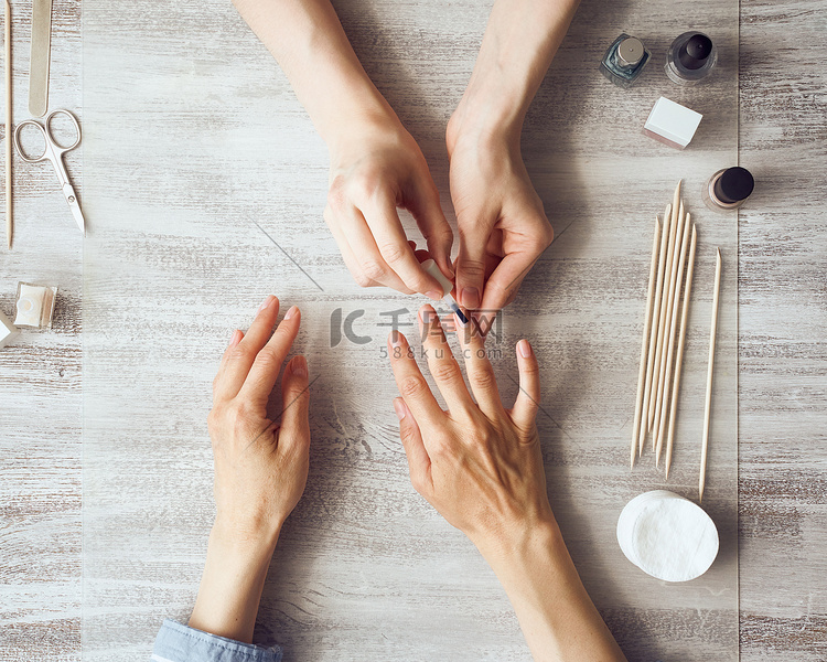 母亲和女儿做指甲，用清漆涂指甲