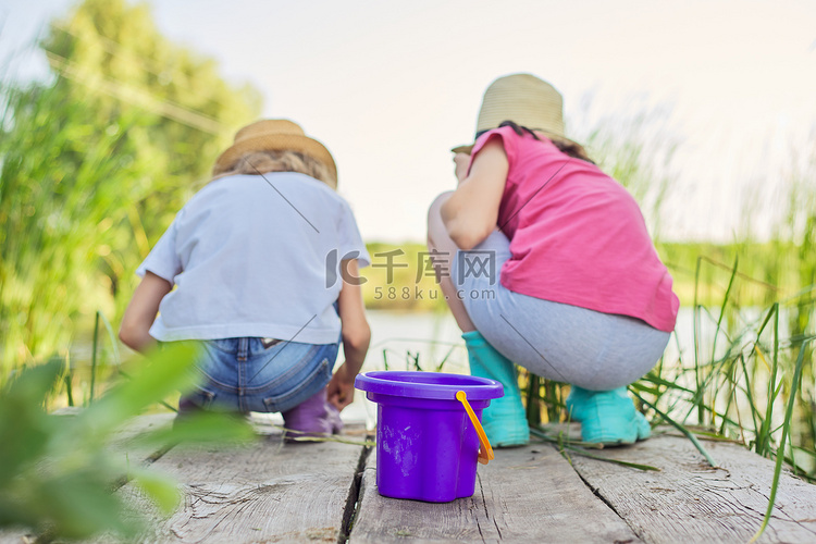 两个女孩一起在芦苇木码头上的湖