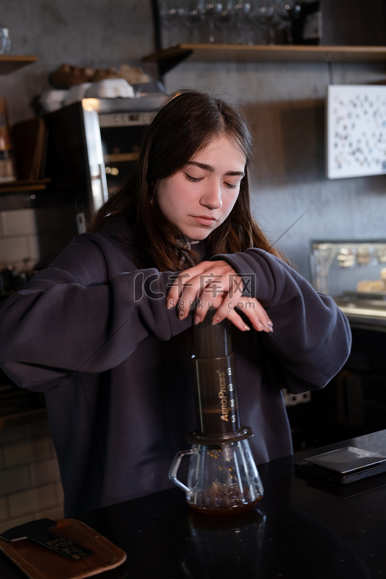 漂亮的黑发女孩在现代咖啡店制作