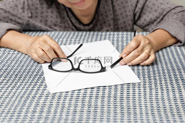 亚洲年长妇女修理破碎的眼镜