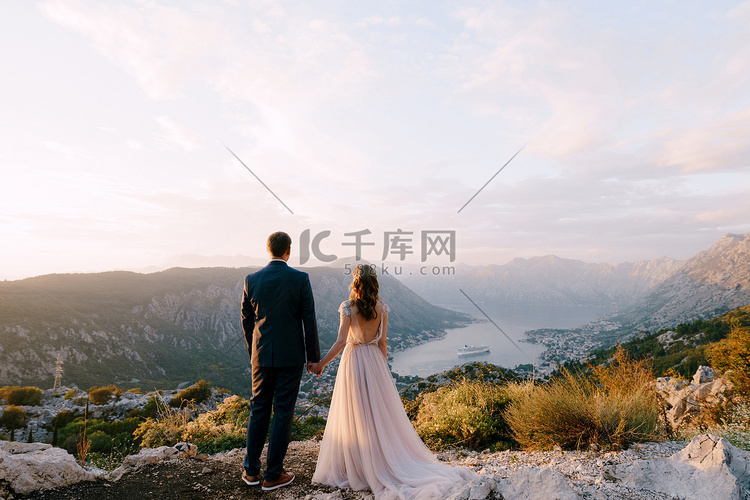 新郎新娘站在山顶眺望山谷。