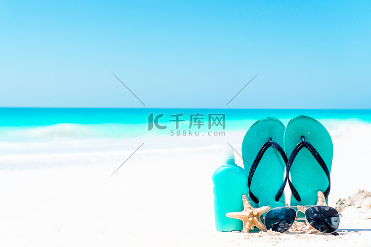 白沙滩背景海洋上的防晒霜瓶、护