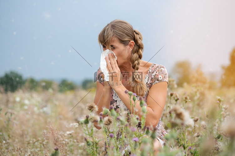 草地上的女人用手帕打喷嚏