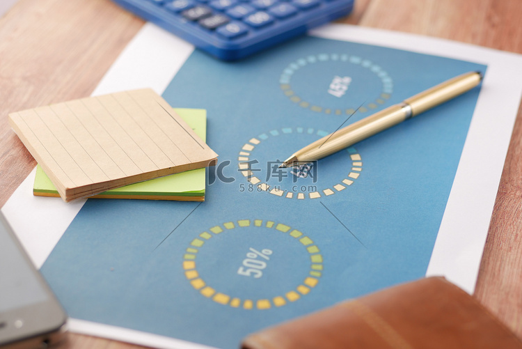 桌上的财务图表、计算器和记事本