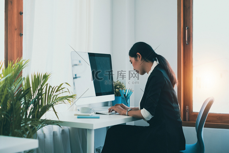 一位女商人使用计算机来确保她的