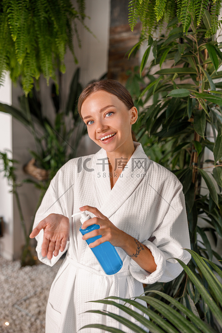 微笑的年轻女性拿着一瓶带凝胶洗