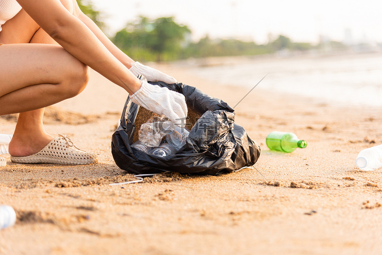 为清洁海滩而将塑料瓶捡进黑色垃