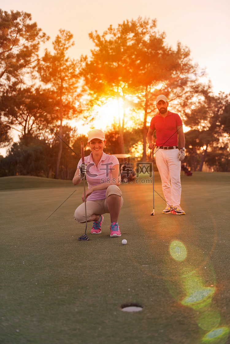 夕阳下高尔夫球场上的情侣