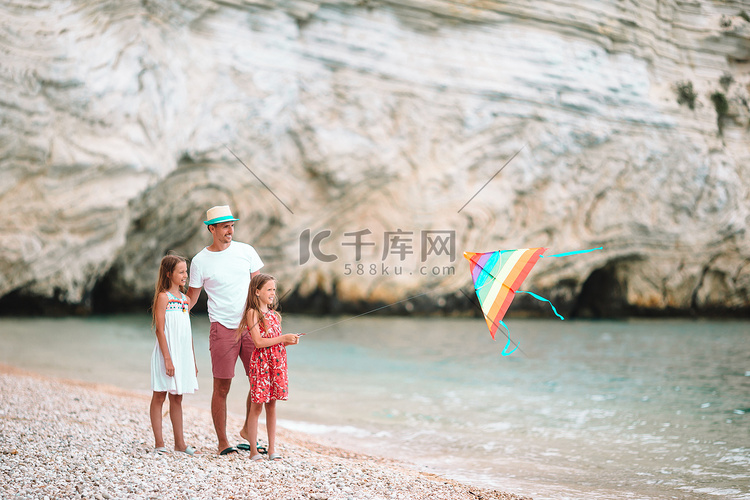 一家人一起在热带白色海滩放风筝