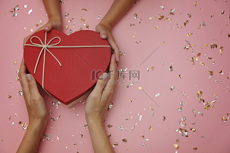 节日粉色背景中的红心形礼盒，有