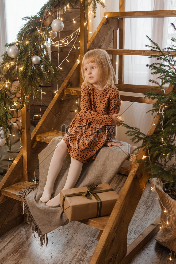 一个金发小女孩坐在装饰着斯堪的