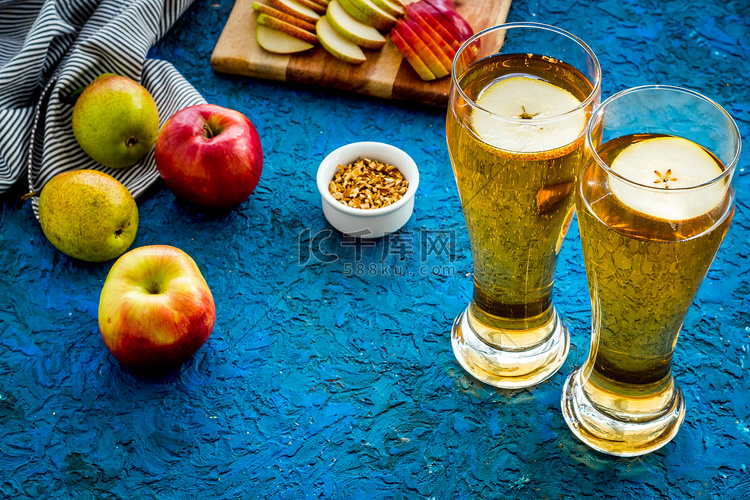 蓝色桌子上的啤酒杯、苹果和同伴