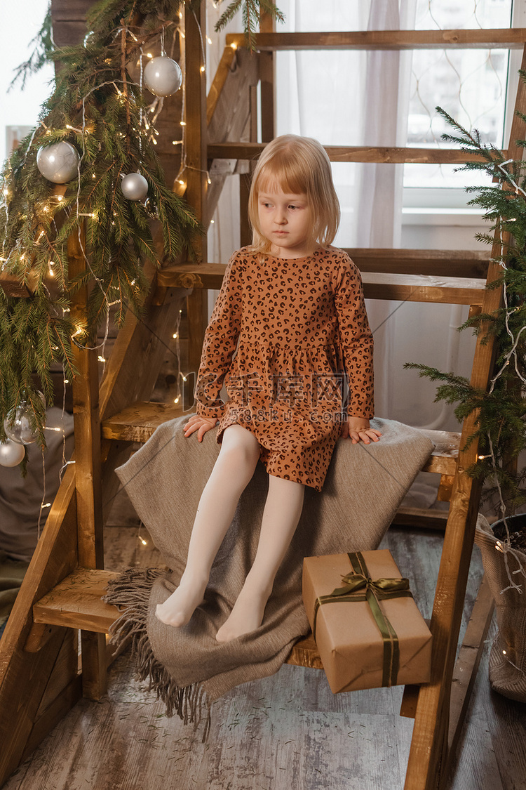 一个金发小女孩坐在装饰着斯堪的