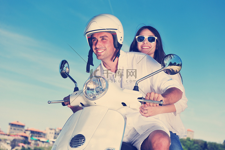 快乐的年轻情侣在滑板车上享受夏