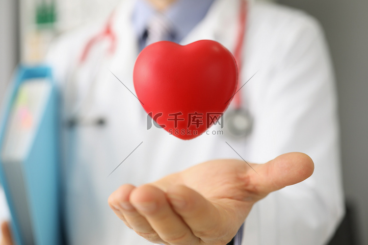 心脏病专家扔红色塑料心，用手掌