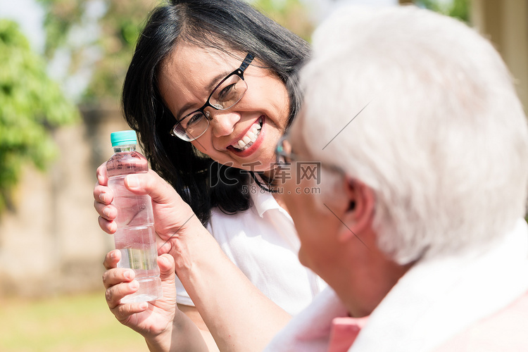 细心的老妇人给她的伴侣送一瓶水
