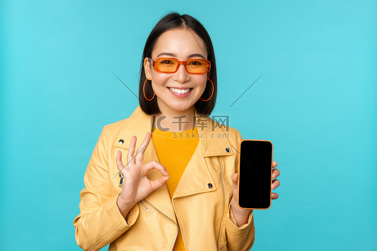 微笑的韩国女性展示手机应用程序